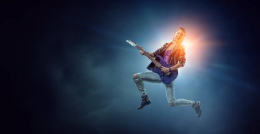 Elektro gitar çalan genç ve güzel bir rock kızı. Karışık ortam