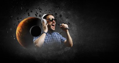 Kulaklıklı genç bir adam. Karışık ortam