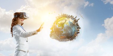 Sanal gerçeklik gözlüğü takan bir kadın. Karışık ortam