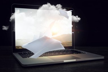 Laptop ve uçan kağıt çarşaflar. Karışık ortam