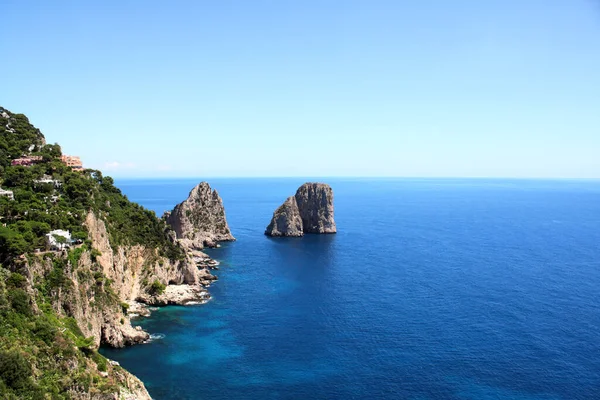 Top view on famous Faraglioni Rocks, Capri Island, Italy. Aerial view of beautiful landscape with azure sea, Capri island coastline and Faraglioni cliffs