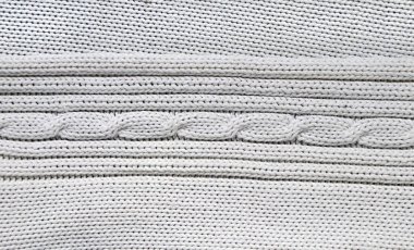 Kablo örgü desenli beyaz renkli yün süveter deseni. Süslü doğal yün beyazı malzeme. El yapımı kumaş dokusuyla yatay veya dikey arkaplan