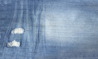 Çivit rengi yırtık kot kumaş. Yırtık delikli mavi renk kot desenli yatay veya dikey arkaplan