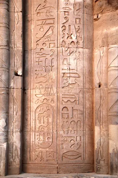 Ancient Egyptian hieroglyphs on stone wall, Com Ombo Temple of gods Horus and crocodile-headed Sobek, Egypt, North Africa.  Com-Ombo Temple wall and columns with carvings hieroglyphs