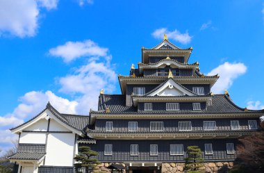 Okayama Kalesi (Kara Kale), Okayama Şehri, Japonya. Meşhur tarihi eser. Okayama 'daki eski Japon Kuzgunlar Kalesi. Mavi gökyüzü arka planında