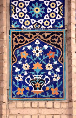 Dikey arka plan, çiçekli ve geometrik süslemeli antik mozaik duvarlar. Duvarda geleneksel fayans dekorasyonu, Buhara, Özbekistan