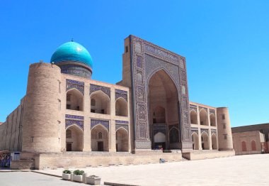 Mir i Arap medresesi, Buhara, Özbekistan. Buhara 'nın eski kentinde, Madrasah Mir Arab, Poi-Kalyan (Poi Kalon) İslami dini kompleksi. Girişteki yazıda Kuran 'dan bir alıntı var.