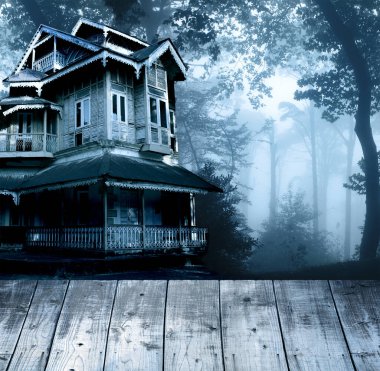 Cadılar Bayramı pankartı, perili ev ve boş tahta masa üstü. Ahşap teras döşemesi ve gece ormanında terk edilmiş bir ev. Gizemli ormanlık alandaki korkunç koloni kulübesi. Fotoğraf mavi tonda.