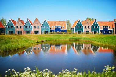 Volendam 'daki deniz parkındaki suya renkli evler yansıdı. Kuzey Hollanda, Hollanda 'daki tipik Hollanda manzarası.