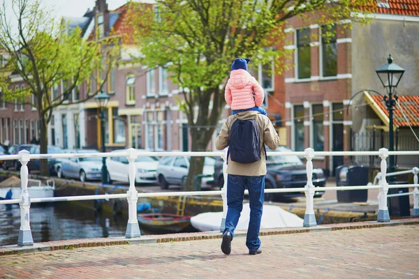 オランダのアルクマールの町を娘と一緒に歩いている父 アルクマールの路上で女子高生の肩を持っている男 — ストック写真