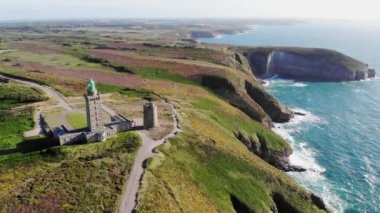 Cape Frehel 'in deniz feneriyle manzarası, Fransa' nın Brittany kentindeki en popüler turizm merkezlerinden biri. Ünlü GR34 izleme yolu boyunca yaygın olarak bilinen turist çekimini gösteren hava aracı görüntüsü