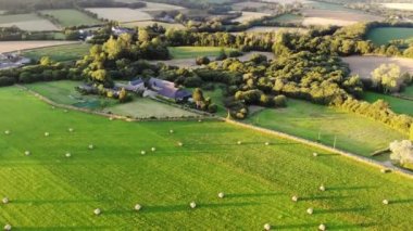 Fransa, Brittany 'deki otlakların ve tarım alanlarının havadan görünüşü. Yeşil tarlaları ve çayırları olan güzel bir Fransız kırsalı. Gün batımında kırsal alan