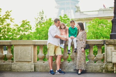 Dört kişilik mutlu bir aile Paris, Fransa seyahatinin tadını çıkarıyor. Anne, baba, oğul ve kız Paris 'teki Eyfel Kulesi yakınlarında. Evli ve çocuklu çift Fransa 'ya seyahat ediyor.