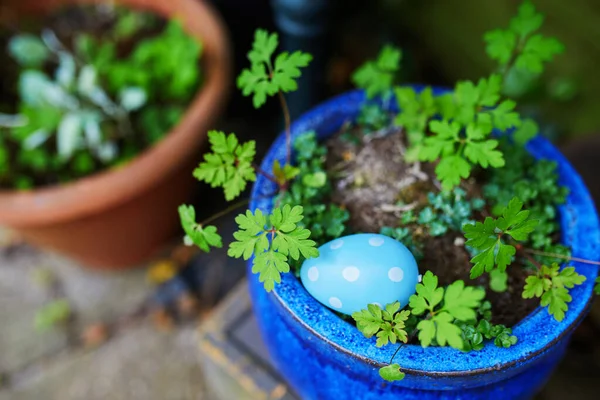 Colored Easter eggs hidden in flower pots for the Easter tradition of egg hunt. Fun Easter activities for kids