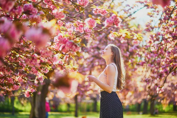 桜の季節に公園で晴れた春の日に美しい若い女性 フランス パリ近郊の有名なスコー公園の若い女性 — ストック写真