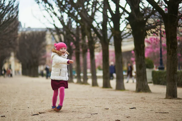 パリの街で楽しい時間を過ごしている陽気な未就学児の女の子 ピンクのマグノリアが咲く春の初めにフランス — ストック写真
