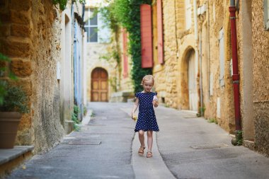 Güney Fransa 'nın Provence kentindeki Lourmarin Ortaçağ köyünde yürüyen sevimli anaokulu kızı.