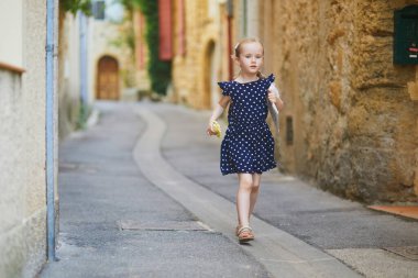 Güney Fransa 'nın Provence kentindeki Lourmarin Ortaçağ köyünde yürüyen sevimli anaokulu kızı.