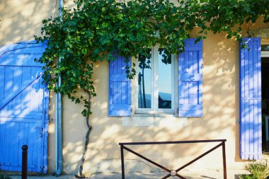 Fransa 'nın Provence kentindeki Bonnieux köyünde mavi panjurlu güzel eski bir bina.
