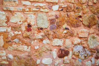 Güney Fransa, Roussillon 'da bir binanın kırmızı tuğlalı duvarı. Roussillon, köyü çevreleyen kilde bulunan büyük deniz tortusu yataklarıyla tanınır.