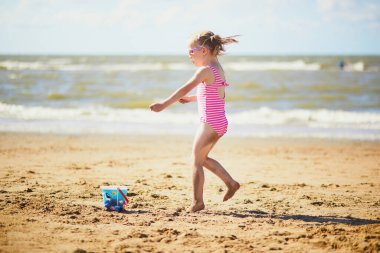 Anaokulu kızı Hollanda, Noordwijk 'teki deniz kıyısında kumsalda eğleniyor. Çocuklar için açık hava yaz aktiviteleri