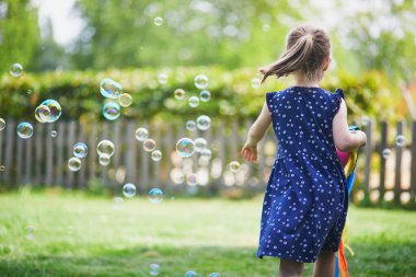 Parkta yürüyen neşeli anaokulu kızı. Çocuklar için açık hava yaz aktiviteleri