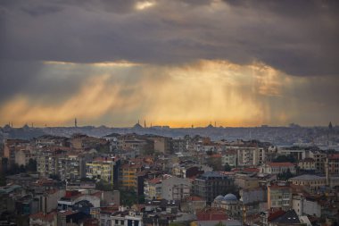 İstanbul 'un Asya yakasındaki Uskudar ilçesi, Türkiye' nin Mavi Cami ve Ayasofya Boğazı üzerinde gün batımında dramatik bir gökyüzü olan Ayasofya manzarası ufukta