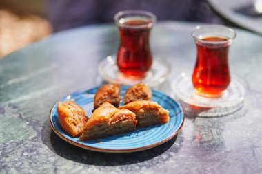Türkiye 'nin İstanbul kentindeki kafe veya restoranda lale şeklinde bardaklarda ve baklava şekerleriyle servis edilen geleneksel Türk çayı