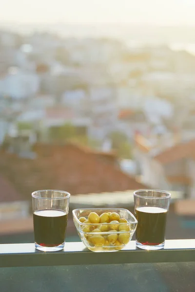 トルコ イスタンブールのアジア側のウスクダル地区の屋根を望む赤ワインと緑のマリネオリーブの2つのグラス — ストック写真