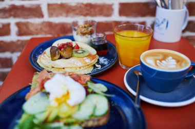 Avokado ve somonlu tost, haşlanmış yumurta, meyveli krep ve akçaağaç şurubu ve Fransa 'nın Kafesi' nde düz beyaz kahve ile nefis sağlıklı bir kahvaltı.