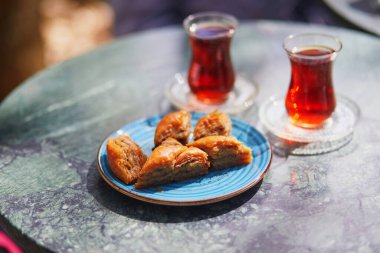 Türkiye 'nin İstanbul kentindeki kafe veya restoranda lale şeklinde bardaklarda ve baklava şekerleriyle servis edilen geleneksel Türk çayı