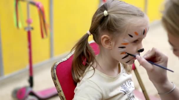 子供たちは絵を描いている メイクアップアーティストは 誕生日のパーティーで虎のような小さな幼稚園児を描いています 子供のためのクリエイティブ活動 — ストック動画