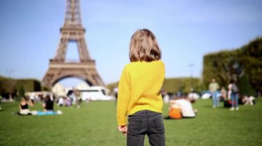 Paris, Fransa 'daki Eyfel Kulesi' ni gösteren sevimli mutlu anaokulu kızı. Çocuklarla seyahat et.