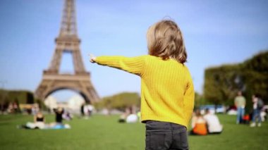 Paris, Fransa 'daki Eyfel Kulesi' ni gösteren sevimli mutlu anaokulu kızı. Çocuklarla seyahat et.