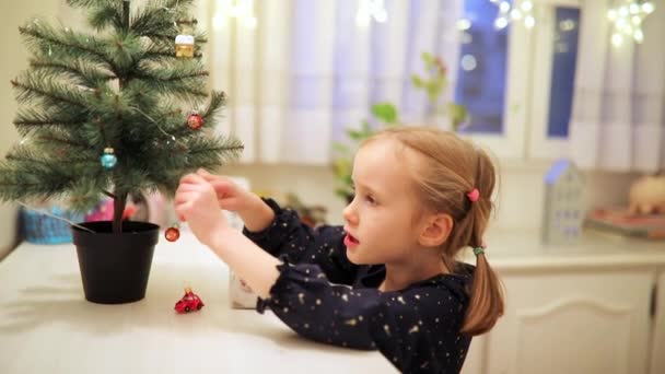 Adorabile Bambino Età Prescolare Decorazione Piccolo Albero Natale Con Giocattoli — Video Stock