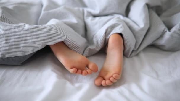 Pikku Lapset Jalat Sängyssä Peiton Peitossa Poika Nukkuu Mukavassa Sängyssä — kuvapankkivideo