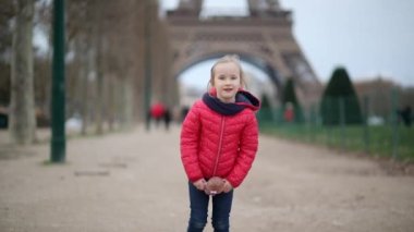 Paris, Fransa 'daki Eyfel Kulesi' nin önünde oyuncak bebeği olan sevimli anaokulu kızı.