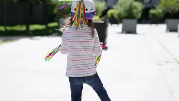 공원에서 스쿠터를 다니는 유니콘 헬멧을 귀여운 아이가 스쿠터를 있습니다 어린이들을 — 비디오