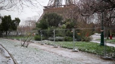 Karlı bir günde Eyfel kulesinin manzarası. Yerde ince bir kar tabakası