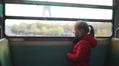 Paris yeraltı treniyle seyahat eden ve Eyfel Kulesi, Paris, Fransa 'nın penceresinden bakan sevimli anaokulu kızı.