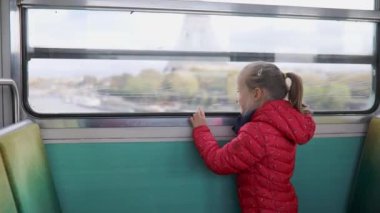 Paris yeraltı treniyle seyahat eden ve Eyfel Kulesi, Paris, Fransa 'nın penceresinden bakan sevimli anaokulu kızı.