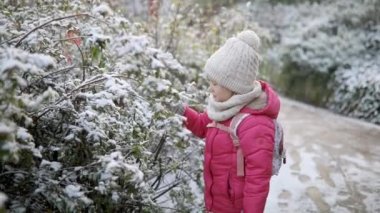 Güzel kış parkında buz gibi bir kış gününde eğlenen sevimli anaokulu kızı. Karda oynayan sevimli bir çocuk. Çocuklu aileler için kış etkinlikleri