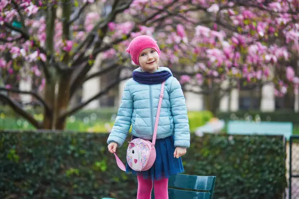 Bedårande Förskoleflicka Njuter Rosa Magnolior Full Blom Regnig Dag Park Royaltyfria Stockfoton