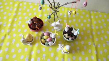 Renkli yumurtalar, tavuklar, lezzetli tatlılar ve çikolatalarla süslenmiş güzel Paskalya masası Paskalya kahvaltısı için servis edilir..