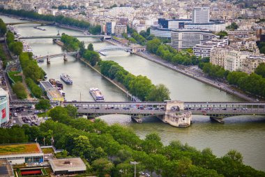 Bir-Hakeim köprüsü, üzerinde metro trenleri ve Paris, Fransa 'da turistik tekneler olan Seine nehrinin havadan manzarası.