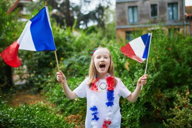 Fransız milli bayrağıyla sevimli anaokulu kızı yarışma sırasında milli takımını destekliyor ve tezahürat yapıyor.