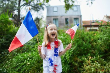 Fransız milli bayrağıyla sevimli anaokulu kızı yarışma sırasında milli takımını destekliyor ve tezahürat yapıyor.