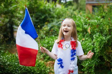 Fransız milli bayrağıyla sevimli anaokulu kızı yarışma sırasında milli takımını destekliyor ve tezahürat yapıyor.