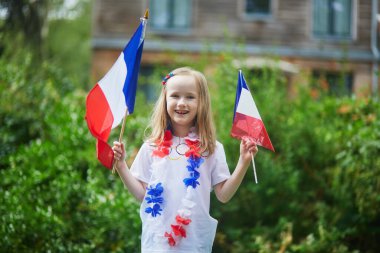 Fransız milli bayrağıyla sevimli anaokulu kızı yarışma sırasında milli takımını destekliyor ve tezahürat yapıyor.