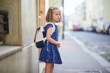 Sırt çantalı, okula gitmeye hazır sevimli anaokulu kızı. Okul konseptinin ilk günü